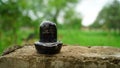 Selective focus on Shivalinga statue, isolated on rough column. Black idol made with marble. Symbol of God Shiva. Royalty Free Stock Photo