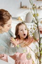 Selective focus of shocked kid looking at decorative easter eggs