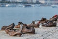 Selective focus of the Shoes on the Danube River Bank with candles and flowers against a river scene