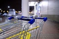 Selective focus on a shopping cart near a supermarket at night. Royalty Free Stock Photo