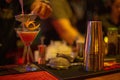 Selective focus shot of a barman pouring a fresh alcoholic drink into the glass on the bar counter Royalty Free Stock Photo