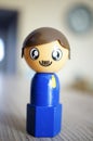 Selective focus shot of a blue lego figure on a wooden surface