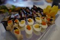 Selective focus shot of boiled stuffed eggs with salmon caviar and eggplant rolls Royalty Free Stock Photo