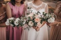 Selective focus shot of the bride and  bridesmaids holding bouquets of beautiful roses Royalty Free Stock Photo