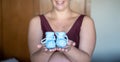 Selective focus shot of a caucasian pregnant woman holding blue baby shoes, indoors Royalty Free Stock Photo
