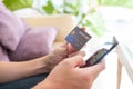 Selective focus shot at credit card mock up. Asian men hand holding credit card while type information into mobile smartphone