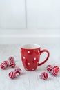 Selective focus shot of a cup of delicious hot coffee surrounded with red little Christmas balls Royalty Free Stock Photo