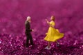 Selective focus shot of cute dancing figurines on a glittered surface