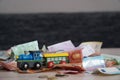 Selective focus shot of different euro banknotes with an train toy on a wooden table