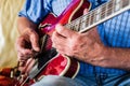 Selective focus shot of an elderly male playing an electric guitar Royalty Free Stock Photo