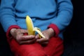 Selective focus shot of an elderly woman holding a half-peeled banana Royalty Free Stock Photo