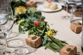 Selective focus shot of an event table decorated with flowers and small mail packages