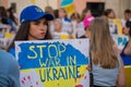 Selective focus shot of a female demonstrator holding a Stop war in Ukraine placard