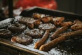 Selective focus shot of frying oily sausages and fresh cutlets in the brazier in the kitchen