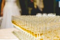 Selective focus shot of glasses of champagne with the bride and groom background Royalty Free Stock Photo