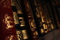 Selective focus shot of gold lettering on antique book covers on a bookshelf