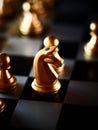 Selective focus shot of golden knight and pawn chess pieces on a chessboard Royalty Free Stock Photo