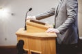 Selective focus shot of a male standing and speaking from the pulpit