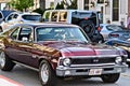 Selective focus shot of a man driving his maroon chevrolet ss car with a blurred background