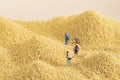 Selective focus shot of miniature backpackers on a pile of grain - hiking concept