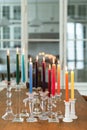 Selective focus shot of multicolored illuminated candles on stands the house