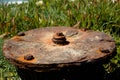Selective focus shot of an old rusty anti-tank mine under the sunlight among the greenery Royalty Free Stock Photo