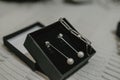 Selective focus shot of a pair of earrings and a bracelet in the black box