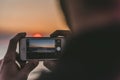 Selective focus shot of a person taking a picture with a smartphone