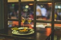 Selective focus shot of plates of shrimp and olives and two wine glasses on a table in a restaurant Royalty Free Stock Photo