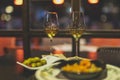 Selective focus shot of plates of shrimp and olives and two wine glasses on a table in a restaurant Royalty Free Stock Photo