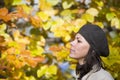 Selective focus shot of a pretty female with brown hat doing breath of fresh autumn air