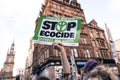 Selective focus shot of a protestor holding a sign saying "Stop Ecocide" in Glasgow, Scotland