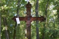 Selective focus shot of a rusty metal cross with a facemask hanging on it in an old cemetery Royalty Free Stock Photo