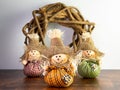 Selective focus shot of scarecrow dolls with a vine ornament on the background