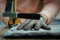 Selective focus shot of seamstress hand with metal gloveworking on sewing machine