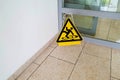 Selective focus shot of a sleepy caution sign on a wet floor