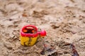 Selective focus shot of a small watering can on the sand Royalty Free Stock Photo