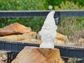 Selective focus shot of a small white plaster figure on a piece of stone