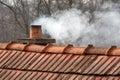 Selective focus shot of the smoke coming out of the chimney of a house Royalty Free Stock Photo