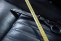 Selective focus shot of a tape measure and scissors on a car seat Royalty Free Stock Photo