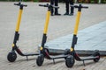 Selective focus shot of three electric scooters on the sidewalk