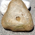 Selective focus shot of a triangular rock with a hole in the center in a blurred background