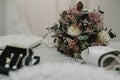 Selective focus shot of the wedding beautiful bouquet with white elegant shoes Royalty Free Stock Photo