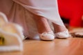 Selective focus shot of white shoes on the feet of the bride