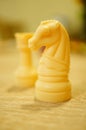 Selective focus shot of a white wooden knight against a white rook