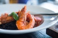 Selective focus on shrimps on black spaghetti pasta