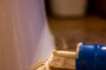 Selective focus on silicone caulking ready to be applied around the seal of a bathroom toilet.