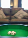 Selective Focus Of Six Dice In A Green Carpeted Tray In A Living Room With A Sofa In The Background