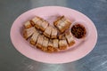 Selective focus, sliced crispy belly pork served on pink plate. Royalty Free Stock Photo