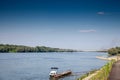 Selective focus on a small boat on the danube river on the serbia croatia river with the ilok backa palanka bridge in background,